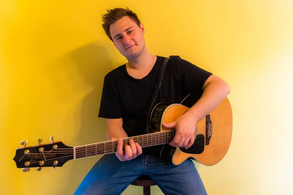 Piotr Nurzyński z gitarą akustyczną